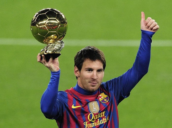 Barcelona's Argentinian forward Lionel Messi poses with the 2011 Ballon d'Or on January 15, 2012 before the Spanish Cup football match opposing FC Barcelona to Real Betis at the Camp Nou stadium in Barcelona. AFP PHOTO/ JOSEP LAGO (Photo by JOSEP LAGO / AFP)