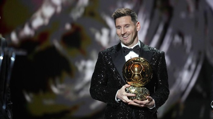 PSG player Lionel Messi receives the 2021 Ballon d'Or trophy from his former Barcelona teammate Luis Suarez during the 65th Ballon d'Or ceremony at Theatre du Chatelet, in Paris, Monday, Nov. 29, 2021. (AP Photo/Christophe Ena)