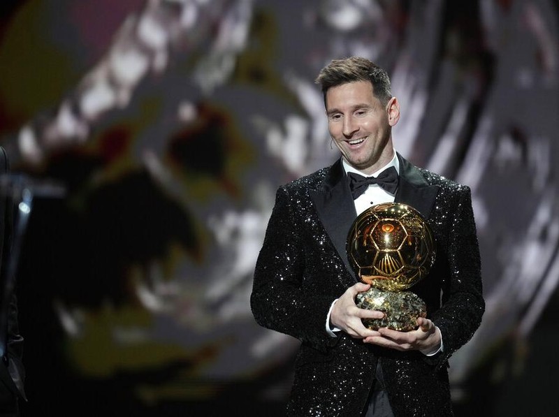 PSG player Lionel Messi receives the 2021 Ballon d'Or trophy from his former Barcelona teammate Luis Suarez during the 65th Ballon d'Or ceremony at Theatre du Chatelet, in Paris, Monday, Nov. 29, 2021. (AP Photo/Christophe Ena)