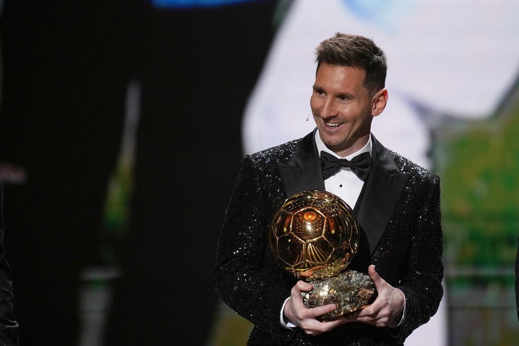 PSG player Lionel Messi receives the 2021 Ballon d'Or trophy from his former Barcelona teammate Luis Suarez during the 65th Ballon d'Or ceremony at Theatre du Chatelet, in Paris, Monday, Nov. 29, 2021. (AP Photo/Christophe Ena)
