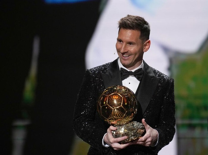 PSG player Lionel Messi receives the 2021 Ballon d'Or trophy from his former Barcelona teammate Luis Suarez during the 65th Ballon d'Or ceremony at Theatre du Chatelet, in Paris, Monday, Nov. 29, 2021. (AP Photo/Christophe Ena)