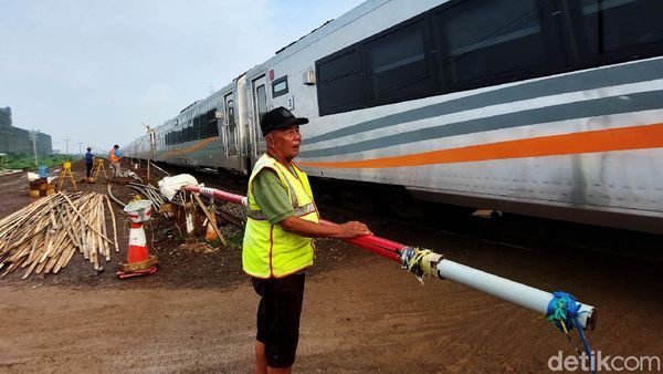 Potret Penjaga Perlintasan KA Berpanas-panasan Demi Keselamatan Pengendara