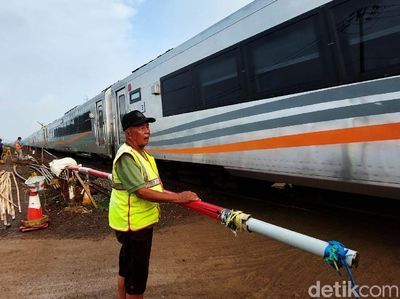 Potret Penjaga Perlintasan KA Berpanas-panasan Demi Keselamatan Pengendara