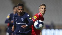 Diogo Calila dari Belenenses berebut bola dengan Alejandro Grimaldo dari Benfica, kanan, selama pertandingan sepak bola Liga Primeira Portugal antara Belenenses SAD dan SL Benfica, Sabtu, (27/11). Belenenses SAD memulai pertandingan dengan hanya sembilan pemain karena wabah virus corona. AP/Pedro Rocha