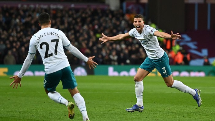 BIRMINGHAM, ENGLAND - DECEMBER 01: Ruben Dias of Manchester City celebrates with teammate Joao Cancelo after scoring their sides first goal during the Premier League match between Aston Villa and Manchester City at Villa Park on December 01, 2021 in Birmingham, England. (Photo by Shaun Botterill/Getty Images)