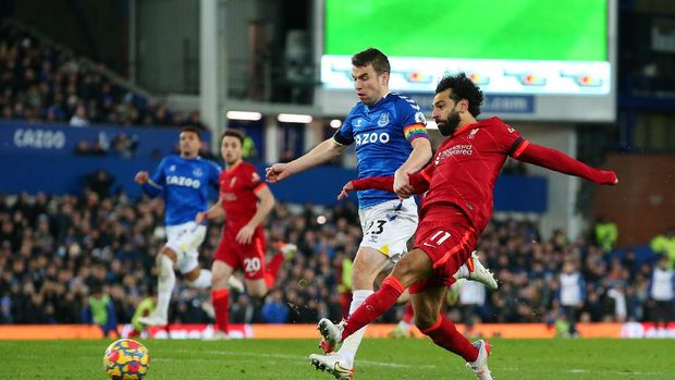 LIVERPOOL, ENGLAND - DECEMBER 01: Mohamed Salah of Liverpool scores their side's third goal whilst under pressure from Seamus Coleman of Everton during the Premier League match between Everton and Liverpool at Goodison Park on December 01, 2021 in Liverpool, England. (Photo by Alex Livesey/Getty Images)