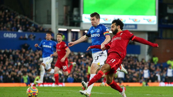 LIVERPOOL, ENGLAND - DECEMBER 01: Mohamed Salah of Liverpool scores their sides third goal whilst under pressure from Seamus Coleman of Everton during the Premier League match between Everton and Liverpool at Goodison Park on December 01, 2021 in Liverpool, England. (Photo by Alex Livesey/Getty Images)