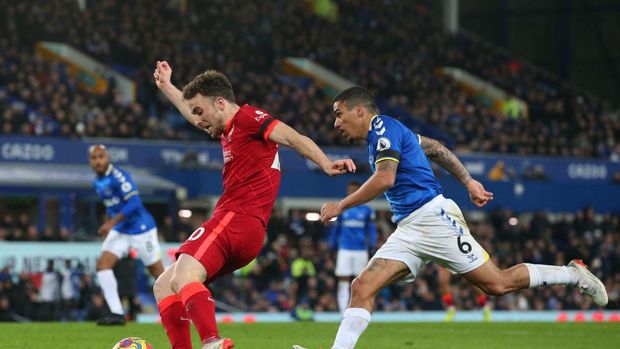 LIVERPOOL, ENGLAND - DECEMBER 01: Diogo Jota of Liverpool scores their side's fourth goal whilst under pressure from Allan of Everton during the Premier League match between Everton and Liverpool at Goodison Park on December 01, 2021 in Liverpool, England. (Photo by Alex Livesey/Getty Images)