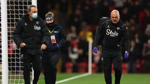 WATFORD, ENGLAND - DECEMBER 01: Watford medical staff who assisted a fan in the crowd walk back to the bench during a break in play during the Premier League match between Watford and Chelsea at Vicarage Road on December 01, 2021 in Watford, England. (Photo by Richard Heathcote/Getty Images)