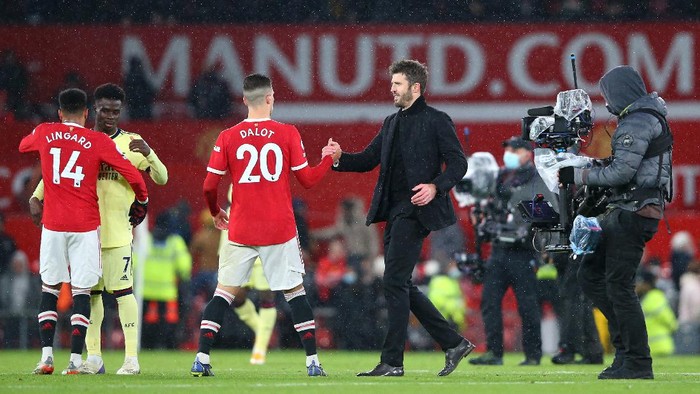 MANCHESTER, ENGLAND - DECEMBER 02: Diogo Dalot of Manchester United shakes hands with Michael Carrick, Interim Manager of Manchester United after the Premier League match between Manchester United and Arsenal at Old Trafford on December 02, 2021 in Manchester, England. (Photo by Alex Livesey/Getty Images)