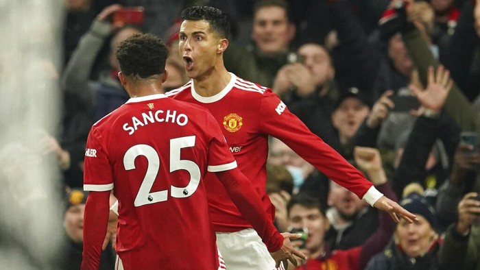 Manchester Uniteds Cristiano Ronaldo, right, celebrates with Manchester Uniteds Jadon Sancho after scoring his sides third goal during the English Premier League soccer match between Manchester United and Arsenal at Old Trafford stadium in Manchester, England, Thursday, Dec. 2, 2021. (AP Photo/Dave Thompson)