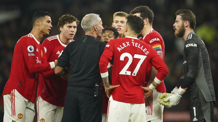 Manchester United players remonstrate with referee Martin Atkinson after he awarded a goal by Arsenals Emile Smith Rowe despite an apparent injury to Manchester Uniteds goalkeeper David de Gea during the English Premier League soccer match between Manchester United and Arsenal at Old Trafford stadium in Manchester, England, Thursday, Dec. 2, 2021. (AP Photo/Dave Thompson)