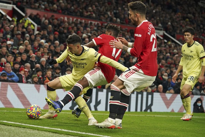 Arsenals Gabriel Martinelli, left, is challenged by Manchester Uniteds Fred during the English Premier League soccer match between Manchester United and Arsenal at Old Trafford stadium in Manchester, England, Thursday, Dec. 2, 2021. (AP Photo/Dave Thompson)
