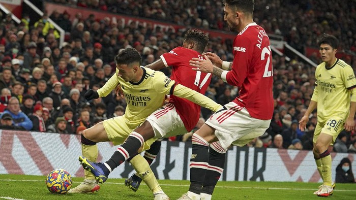 Arsenals Gabriel Martinelli, left, is challenged by Manchester Uniteds Fred during the English Premier League soccer match between Manchester United and Arsenal at Old Trafford stadium in Manchester, England, Thursday, Dec. 2, 2021. (AP Photo/Dave Thompson)