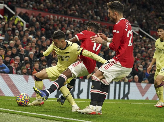 Arsenals Gabriel Martinelli, left, is challenged by Manchester Uniteds Fred during the English Premier League soccer match between Manchester United and Arsenal at Old Trafford stadium in Manchester, England, Thursday, Dec. 2, 2021. (AP Photo/Dave Thompson)