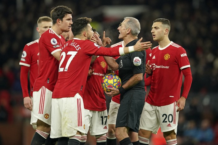 Manchester United players remonstrate with referee Martin Atkinson after he awarded a goal by Arsenals Emile Smith Rowe despite an apparent injury to Manchester Uniteds goalkeeper David de Gea during the English Premier League soccer match between Manchester United and Arsenal at Old Trafford stadium in Manchester, England, Thursday, Dec. 2, 2021. (AP Photo/Dave Thompson)