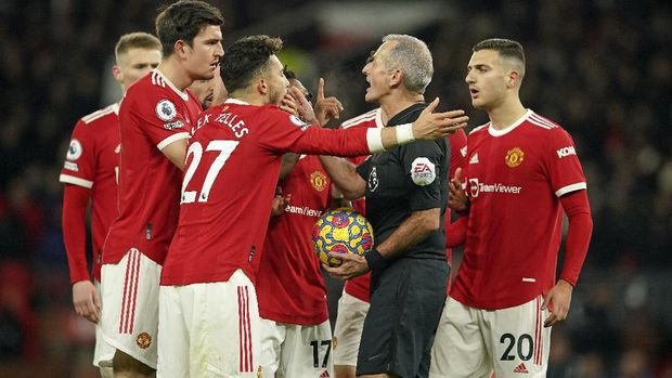 Manchester United players remonstrate with referee Martin Atkinson after he awarded a goal by Arsenal's Emile Smith Rowe despite an apparent injury to Manchester United's goalkeeper David de Gea during the English Premier League soccer match between Manchester United and Arsenal at Old Trafford stadium in Manchester, England, Thursday, Dec. 2, 2021. (AP Photo/Dave Thompson)