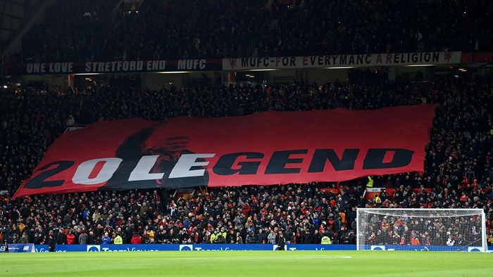 MU vs Arsenal, Ole Gunnar Solskjaer MANCHESTER, ENGLAND - DECEMBER 02: Fans of Manchester United wave a flag in support of Former Player and Manager, Ole Gunnar Solskjaer prior to the Premier League match between Manchester United and Arsenal at Old Trafford on December 02, 2021 in Manchester, England. (Photo by Shaun Botterill/Getty Images)