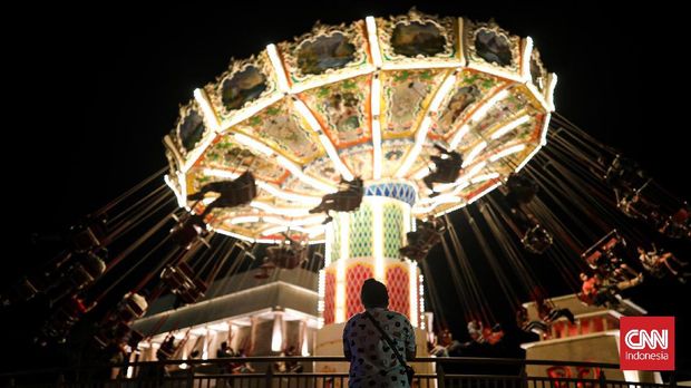 Pengunjung menaiki wahana permainan di Dunia Fantasi, Ancol, Jakarta, Jumat (3/12/2021). Pada bulan November ini, Dufan kembali menghadirkan sebuah acara yang akan mengobati kerinduan para pengunjung untuk bisa menikmati serunya rekreasi pada malam hari dengan menghadirkan penampilan Parade Elektrik yang memukau disertai permainan lampu berwarna warni dan menikmati pengalaman seru menaiki wahana-wahana populer. CNN Indonesia/Adi Maulana Ibrahim