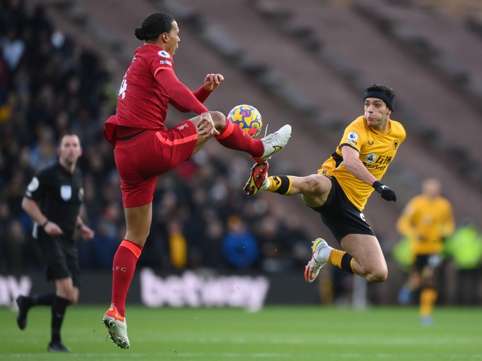 WOLVERHAMPTON, ENGLAND - DECEMBER 04: Virgil van Dijk of Liverpool is challenged by Raul Jimenez of Wolverhampton Wanderers during the Premier League match between Wolverhampton Wanderers and Liverpool at Molineux on December 04, 2021 in Wolverhampton, England. (Photo by Laurence Griffiths/Getty Images)