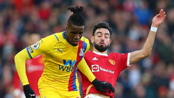 MANCHESTER, ENGLAND - DECEMBER 05: Wilfried Zaha of Crystal Palace is tackled by Bruno Fernandes of Manchester United during the Premier League match between Manchester United and Crystal Palace at Old Trafford on December 05, 2021 in Manchester, England. (Photo by Alex Livesey/Getty Images)