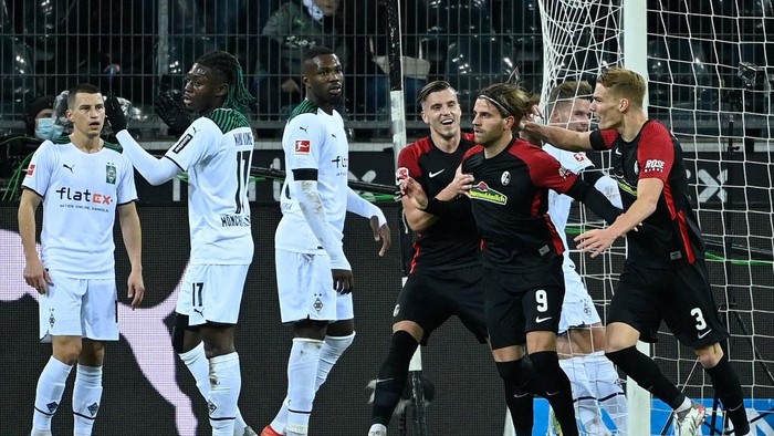 Freiburgs German forward Lucas Hoeler (2nd R) celebrates scoring the 0-5 with his teammates during the German first division Bundesliga football match Borussia Moenchengladbach v SC Freiburg in Moenchengladbach, western Germany, on December 5, 2021. (Photo by Ina Fassbender / AFP) / DFL REGULATIONS PROHIBIT ANY USE OF PHOTOGRAPHS AS IMAGE SEQUENCES AND/OR QUASI-VIDEO