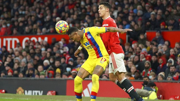 Crystal Palace's Nathaniel Clyne, left, heads the ball ahead of Manchester United's Cristiano Ronaldo during the English Premier League soccer match between Manchester United and Crystal Palace at Old Trafford stadium in Manchester, England, Sunday, Dec. 5, 2021. (AP Photo/Jon Super)