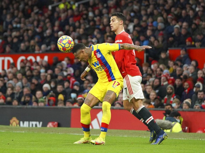 Crystal Palace's Nathaniel Clyne, left, heads the ball ahead of Manchester United's Cristiano Ronaldo during the English Premier League soccer match between Manchester United and Crystal Palace at Old Trafford stadium in Manchester, England, Sunday, Dec. 5, 2021. (AP Photo/Jon Super)