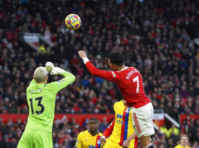 Crystal Palace's goalkeeper Vicente Guaita, left, punches the ball away under pressure from Manchester United's Cristiano Ronaldo, right, during the English Premier League soccer match between Manchester United and Crystal Palace at Old Trafford stadium in Manchester, England, Sunday, Dec. 5, 2021. (AP Photo/Jon Super)