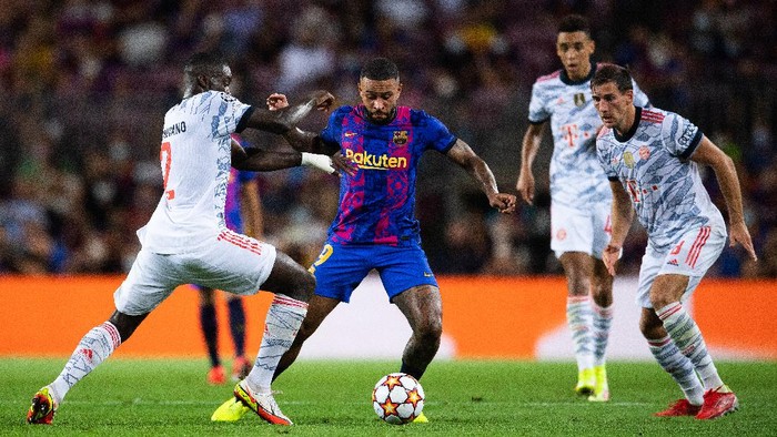 BARCELONA, SPAIN - SEPTEMBER 14: Memphis Depay of FC Barcelona competes for the ball with Dayot Upamecano and Leon Goretzka of Bayern München during the UEFA Champions League group E match between FC Barcelona and Bayern München at Camp Nou on September 14, 2021 in Barcelona, Spain. (Photo by David Ramos/Getty Images)