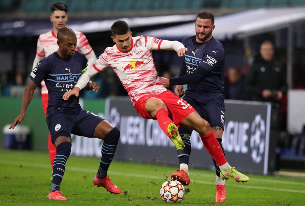 Leipzig's Portugese forward Andre Silva (C) is fouled by Manchester City's English defender Kyle Walker (R) before being sent off next to Manchester City's Brazilian midfielder Fernandinho during the UEFA Champions League, Group A, football match RB Leipzig v Manchester City in Leipzig, eastern Germany on December 7, 2021. (Photo by Ronny HARTMANN / AFP)