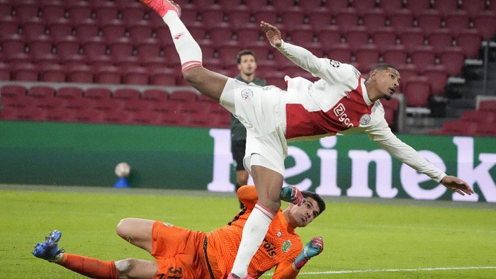Ajaxs Sebastien Haller, top, collides with Sportings goalkeeper Joao Virginia during a Champions League group C soccer match between Ajax and Sporting CP, at the at the Johan Cruyff ArenA in Amsterdam, Netherlands, Tuesday, Dec. 7, 2021. (AP Photo/Peter Dejong)