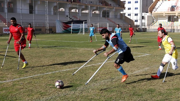 Sepakbola Amputasi Gaza Orang-orang Palestina yang diamputasi bertanding dalam pertandingan sepak bola dengan menggunakan tongkat mereka selama sesi latihan, di Stadion Palestina di Kota Gaza, Minggu, 5 Desember 2021. Komite Internasional Palang Merah, bekerja sama dengan Asosiasi Sepak Bola Orang Cacat Palestina, mensponsori proses panjang tersebut. dalam membentuk tim nasional. Para pemain berharap untuk bersaing secara regional, pandangan mereka tertuju pada Piala Dunia untuk orang yang diamputasi di Turki Oktober mendatang. (Foto AP/Adel Hana)