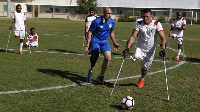 Sepakbola Amputasi Gaza Orang-orang Palestina yang diamputasi bertanding dalam pertandingan sepak bola dengan menggunakan tongkat mereka selama sesi latihan, di Stadion Palestina di Kota Gaza, Minggu, 5 Desember 2021. Komite Internasional Palang Merah, bekerja sama dengan Asosiasi Sepak Bola Orang Cacat Palestina, mensponsori proses panjang tersebut. dalam membentuk tim nasional. Para pemain berharap untuk bersaing secara regional, pandangan mereka tertuju pada Piala Dunia untuk orang yang diamputasi di Turki Oktober mendatang. (Foto AP/Adel Hana)