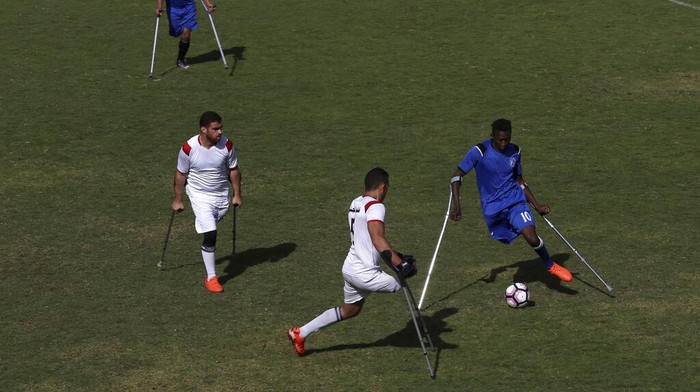 Orang-orang Palestina yang diamputasi bertanding dalam pertandingan sepak bola dengan menggunakan tongkat mereka selama sesi latihan, di Stadion Palestina di Kota Gaza, Minggu, 5 Desember 2021. Komite Internasional Palang Merah, bekerja sama dengan Asosiasi Sepak Bola Orang Cacat Palestina, mensponsori proses panjang tersebut. dalam membentuk tim nasional. Para pemain berharap untuk bersaing secara regional, pandangan mereka tertuju pada Piala Dunia untuk orang yang diamputasi di Turki Oktober mendatang. (Foto AP/Adel Hana)