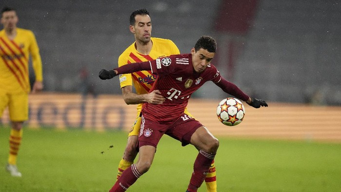 Barcelonas Sergio Busquets, background, holds Bayerns Jamal Musiala during the Champions League group E soccer match between Bayern Munich and FC Barcelona in Munich, Germany, Wednesday, Dec. 8, 2021. (AP Photo/Matthias Schrader)