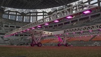 Pekerja menggunakan alat grass grow lighting untuk perawatan rumput lapangan Jakarta International Stadium (JIS) di Tanjung Priok, Jakarta, Kamis (9/12/2021).