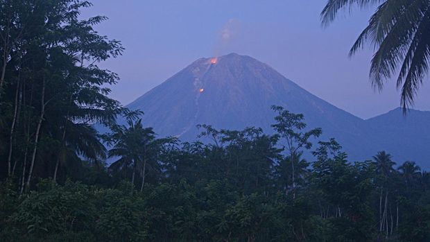 Gunung Semeru mengeluarkan lava pijar yang terlihat dari Desa Jarit, Candipuro, Lumajang, Jawa Timur, Jumat (10/12/2021). Pusat Vulkanologi dan Mitigasi Bencana Geologi (PVMBG) dalam laporan per 6 jam menyatakan Gunung Semeru berstatus level dua atau waspada dan meminta masyarakat dalam jarak lima kilometer arah bukaan kawah di sektor selatan dan tenggara untuk mewaspadai awan panas guguran, guguran lava, dan lahar di sepanjang aliran sungai atau lembah yang berhulu di puncak Gunung Semeru. ANTARA FOTO/Seno/aww.