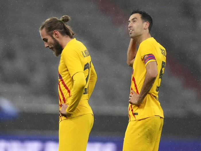 Barcelonas Oscar Mingueza, left, and Sergio Busquets stand on the pitch after the Champions League group E soccer match between Bayern Munich and FC Barcelona in Munich, Germany, Wednesday, Dec. 8, 2021. Bayern won 3-0. (AP Photo/Matthias Schrader)