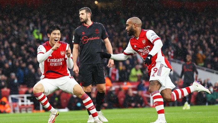 LONDON, ENGLAND - DECEMBER 11: Alexandre Lacazette of Arsenal celebrates with teammate Takehiro Tomiyasu after scoring their sides first goal during the Premier League match between Arsenal and Southampton at Emirates Stadium on December 11, 2021 in London, England. (Photo by Eddie Keogh/Getty Images)
