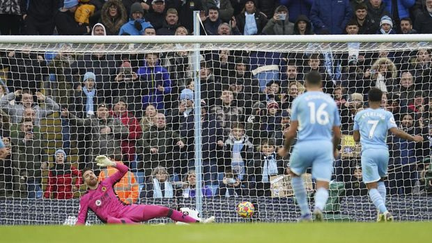 Manchester City's Raheem Sterling, right, scores his side's first goal on a penalty kick during the English Premier League soccer match between Manchester City and Wolverhampton Wanderers, at the Etihad stadium in Manchester, England, Saturday, Dec.11, 2021. (AP Photo/Dave Thompson)