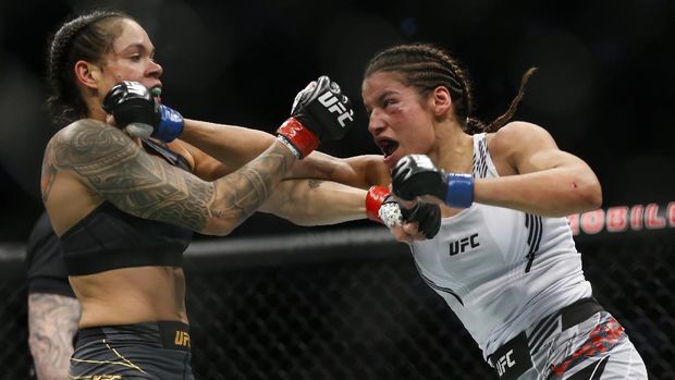 Julianna Pena, right, hits Amanda Nunes during a women's bantamweight mixed martial arts title bout at UFC 269, Saturday, Dec. 11, 2021, in Las Vegas. (AP Photo/Chase Stevens)