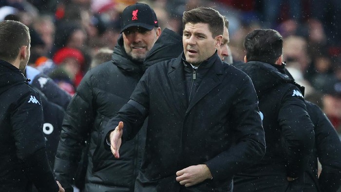 LIVERPOOL, ENGLAND - DECEMBER 11: Steven Gerrard, Manager of Aston Villa shakes hands with a member of the Liverpool backroom staff as Jurgen Klopp, Manager of Liverpool looks on behind prior to the Premier League match between Liverpool and Aston Villa at Anfield on December 11, 2021 in Liverpool, England. (Photo by Clive Brunskill/Getty Images)