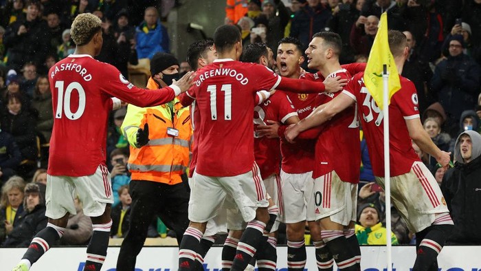 NORWICH, ENGLAND - DECEMBER 11: Cristiano Ronaldo of Manchester United celebrates with team mates after scoring their sides first goal during the Premier League match between Norwich City and Manchester United at Carrow Road on December 11, 2021 in Norwich, England. (Photo by Alex Pantling/Getty Images)
