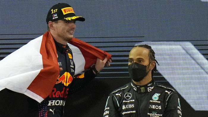 Pembalap Red Bull Max Verstappen dari Belanda melakukan selebrasi usai menjadi juara dunia setelah menjuarai Formula Satu Grand Prix Abu Dhabi di Abu Dhabi, Uni Emirat Arab, Minggu, 12 Desember 2021, Di sebelah kanan adalah posisi kedua pembalap Mercedes Lewis Hamilton dari Inggris. (Foto AP/Hassan Ammar)