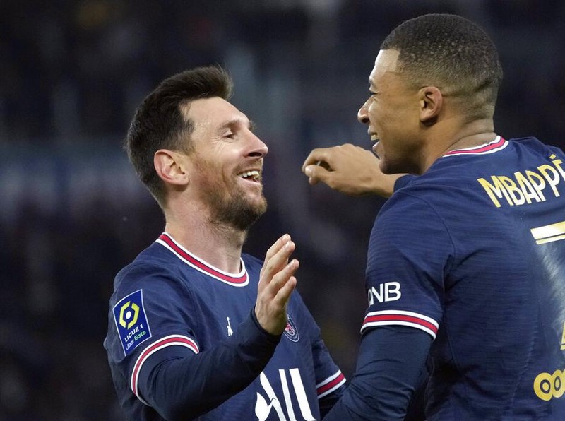 PSG's Kylian Mbappe, centre, celebrates with PSG's Lionel Messi after scoring his side's second goal during the French League One soccer match between Paris Saint-Germain and Monaco at the Parc des Princes stadium in Paris, France, Sunday, Dec. 12, 2021. (AP Photo/Christophe Ena)