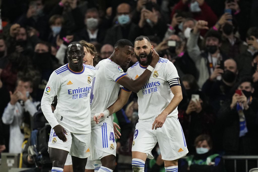 Real Madrid's Karim Benzema, right, celebrates with teammates after scoring the opening goal during the Spanish La Liga soccer match between Real Madrid and Atletico Madrid at Santiago Bernabeu stadium in Madrid, Spain, Sunday, Dec. 12, 2021. (AP Photo/Bernat Armangue)