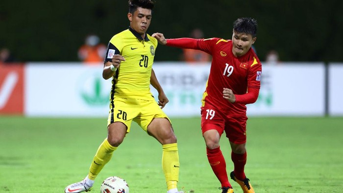 SINGAPORE, SINGAPORE - DECEMBER 12: Syafiq Ahmad #20 of Malaysia controls the ball against Nguyen Quang Hai #19 of Vietnam during the first half of their AFF Suzuki Cup Group B game at Bishan Stadium on December 12, 2021 in Singapore. (Photo by Yong Teck Lim/Getty Images)