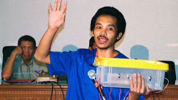 Indonesian chief investigator for the Bali bombing, I Made Pastika (L), looks on as key suspect Ali Imron (R) explains how the bombs were assembled during a press conference at police headquarters in Denpasar, Bali, 11 February 2003.  Ali Imron publicly admitted his role in the Bali terror blasts and gave details of how the deadly attacks were carried out.    AFP PHOTO/DARMA (Photo by DARMA / AFP)
