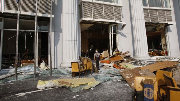 An Indonesian policeman stands amongst the debris of a bomb blast at the Ritz-Carlton hotel in Jakarta on July 18, 2009. A Malaysian extremist wanted for a string of terror attacks has been named as the man most likely behind twin suicide bombings at luxury hotels in Indonesia which killed at least nine people. Police were studying explosives found in the suspects' 